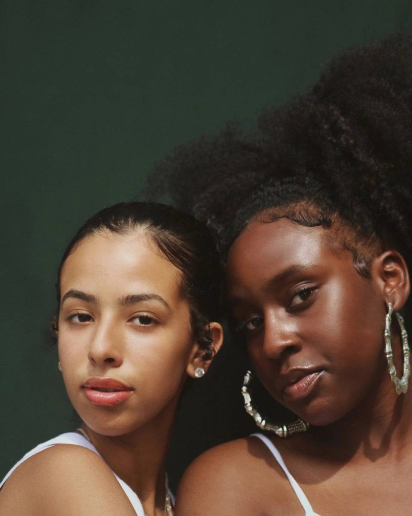 photo of two women who curly and straight hair showcasing hair care products by Sate Haircare